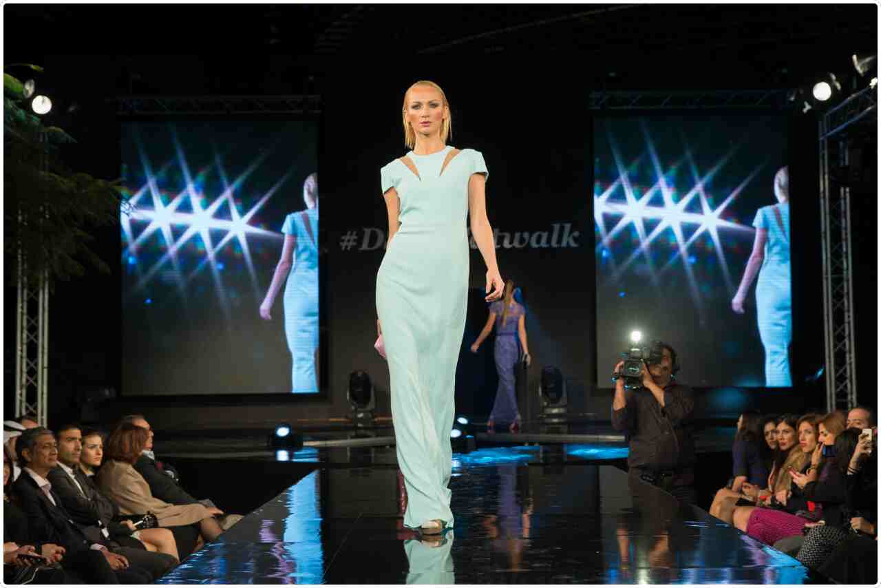 Fashion model strutting confidently on the runway during a glamorous show.